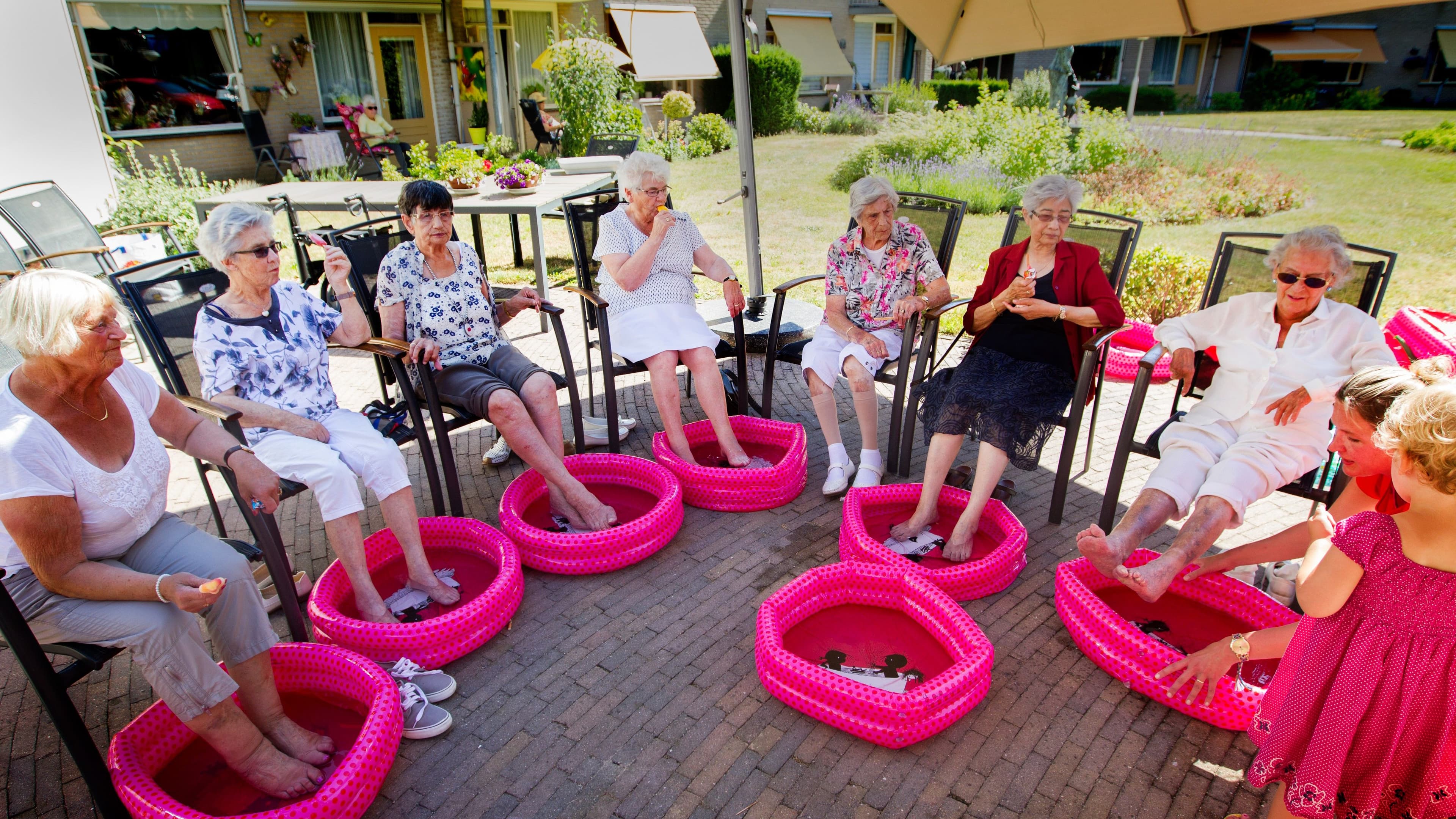 Bejaarden met de voeten in een kinderbadje tegen de hitte