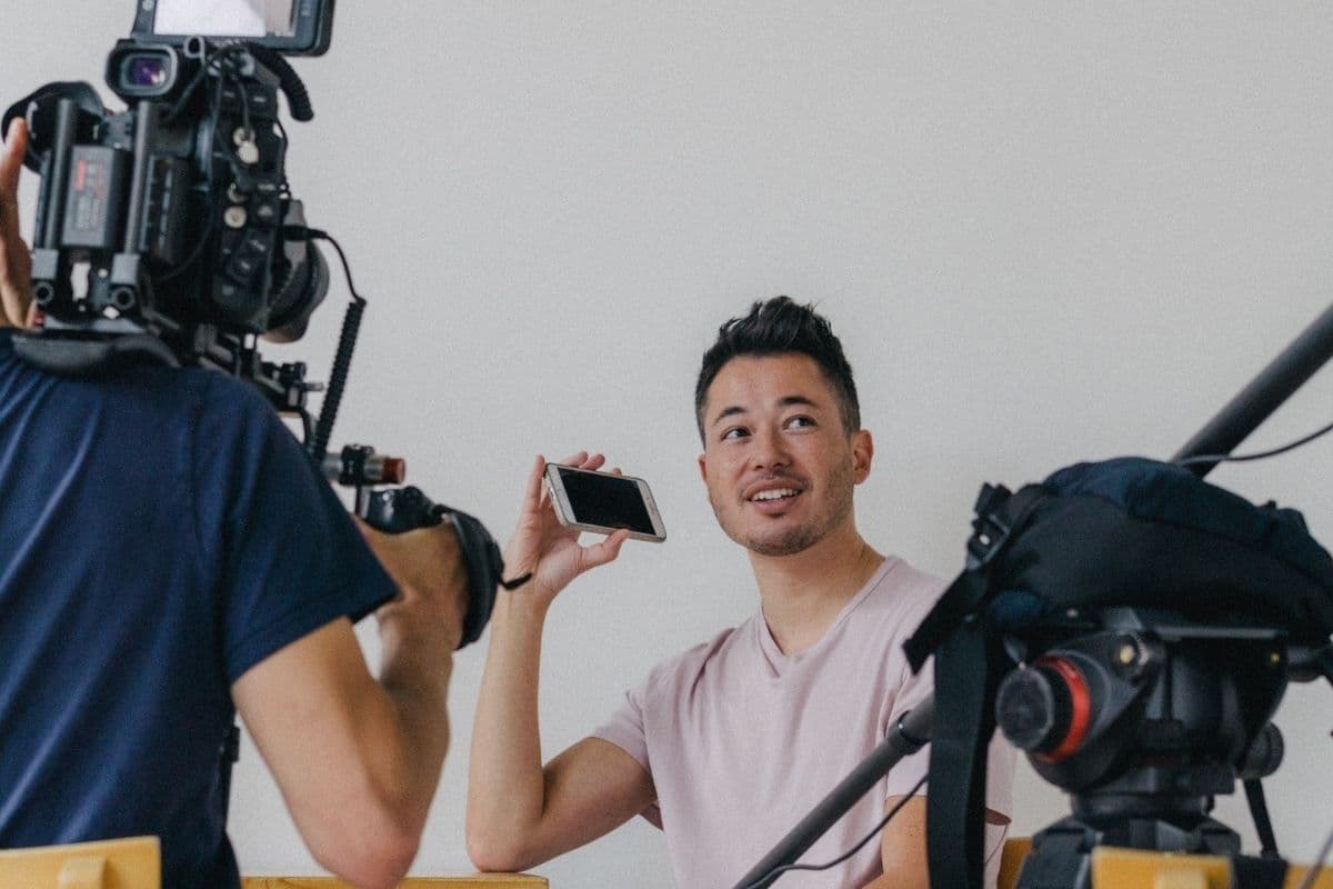 Joji Na met een iphone in zijn hand terwijl hij gefilmd wordt