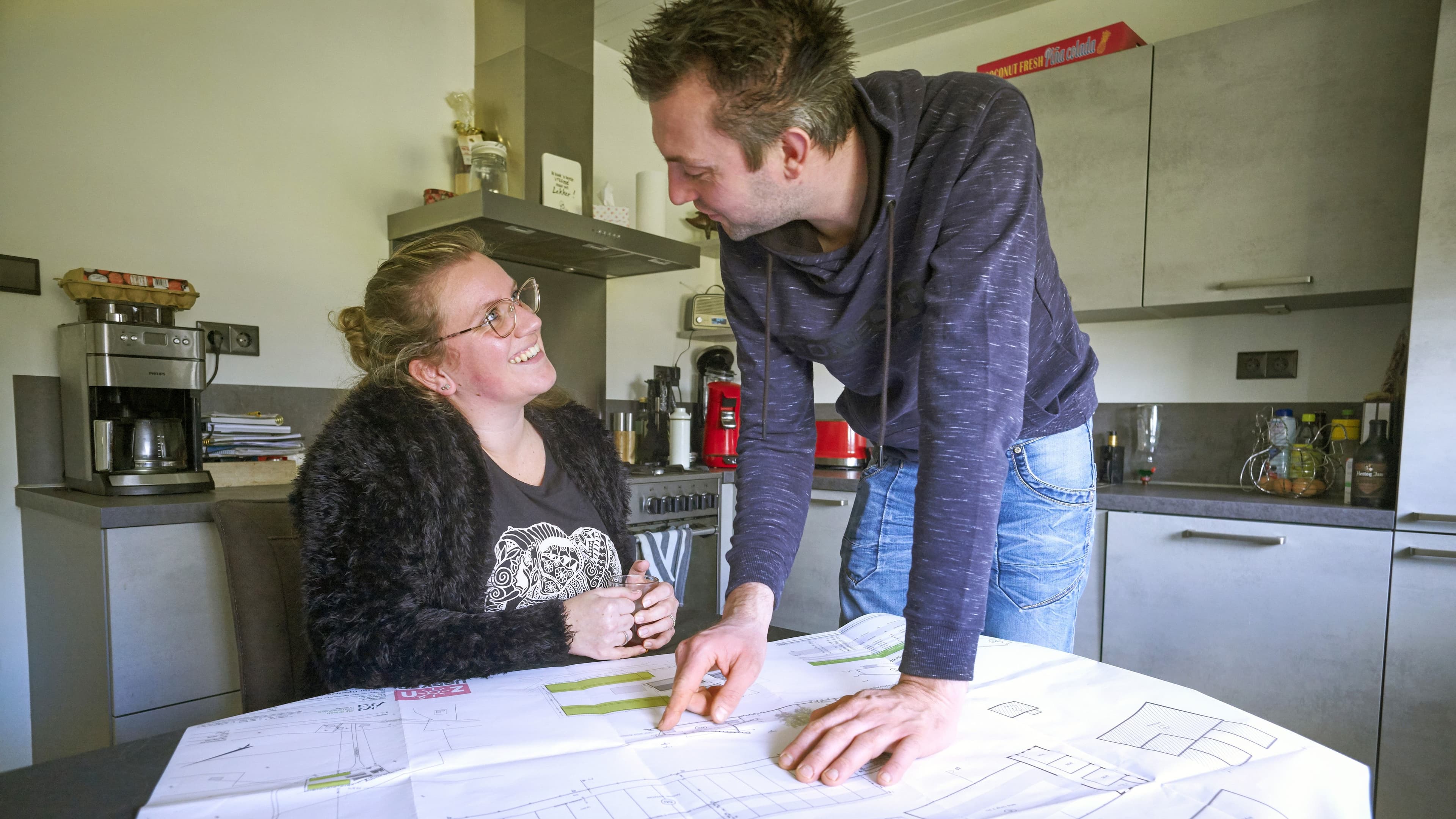Boeren stel aan de keukentafel met technische tekening voor zich